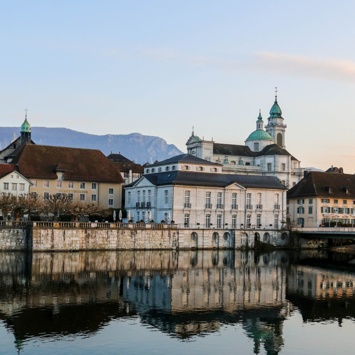 Kathedrale St. Ursen in Solothurn im Morgenlicht mit Aare im Vordergrund als Symbolbild für die Region Solothurn von Sauberhaft.